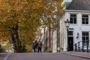 Stelletje lopend over de Amsterdamse Grachten